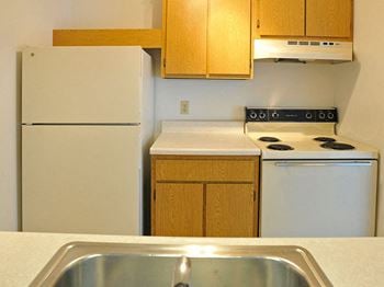 White kitchen appliances at Charter Oaks Apartments in Davison, MI